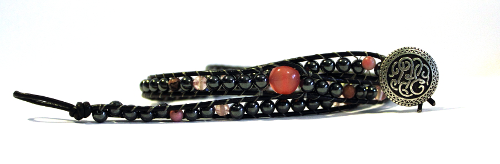 A wrap bracelet made with hematite, cherry quartz, and cats eye glass, with a celtic knot button